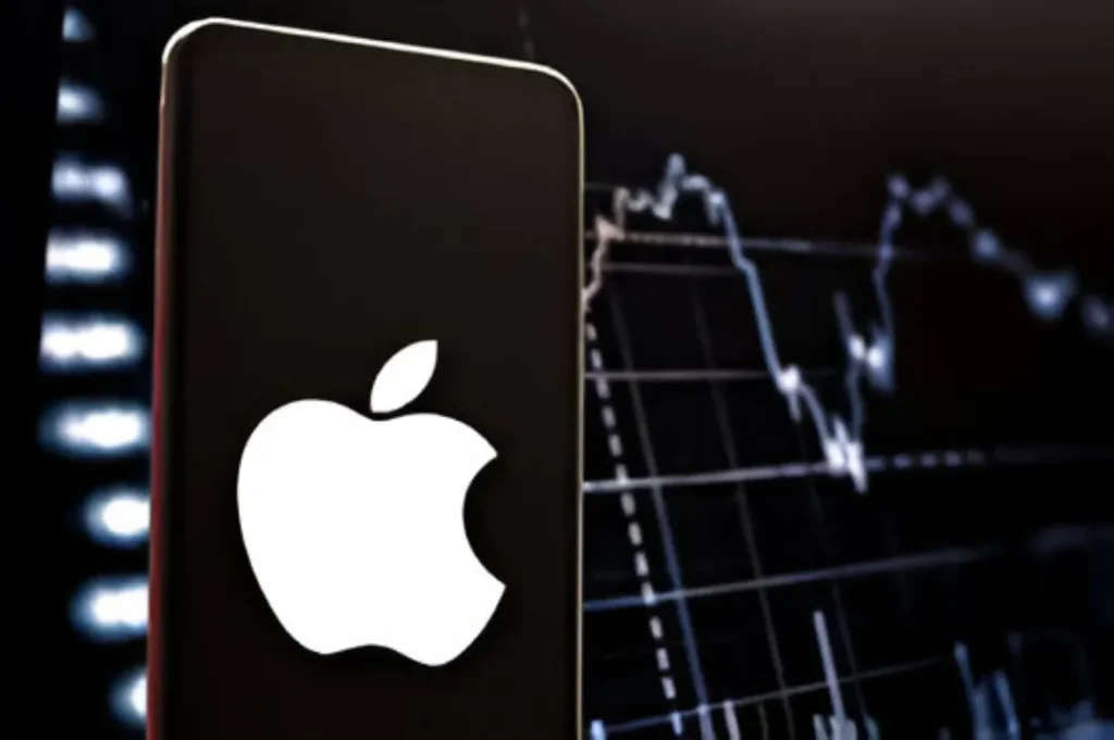 The white Apple logo displayed prominently on a smartphone screen, with a blurred background showing financial market charts and graphs, symbolizing Apple's stock performance (AAPL).