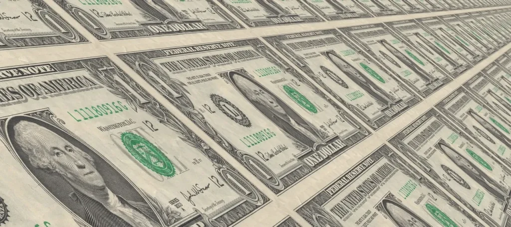 A large number of crisp one-dollar bills laid out in neat rows at a slight angle, creating a visual representation of currency.