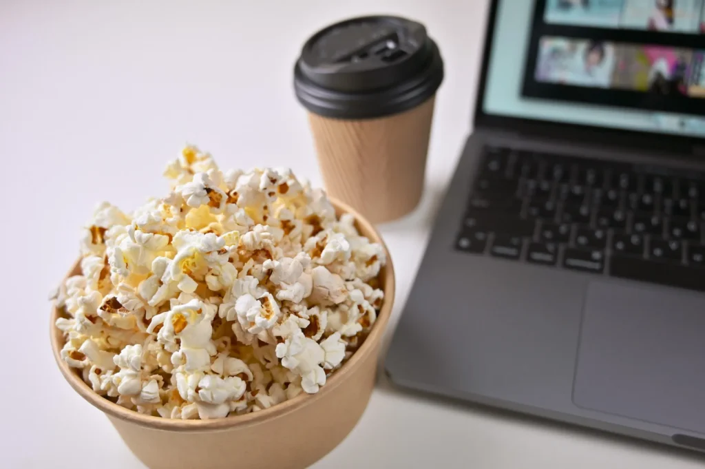 popcorn next to laptop streaming